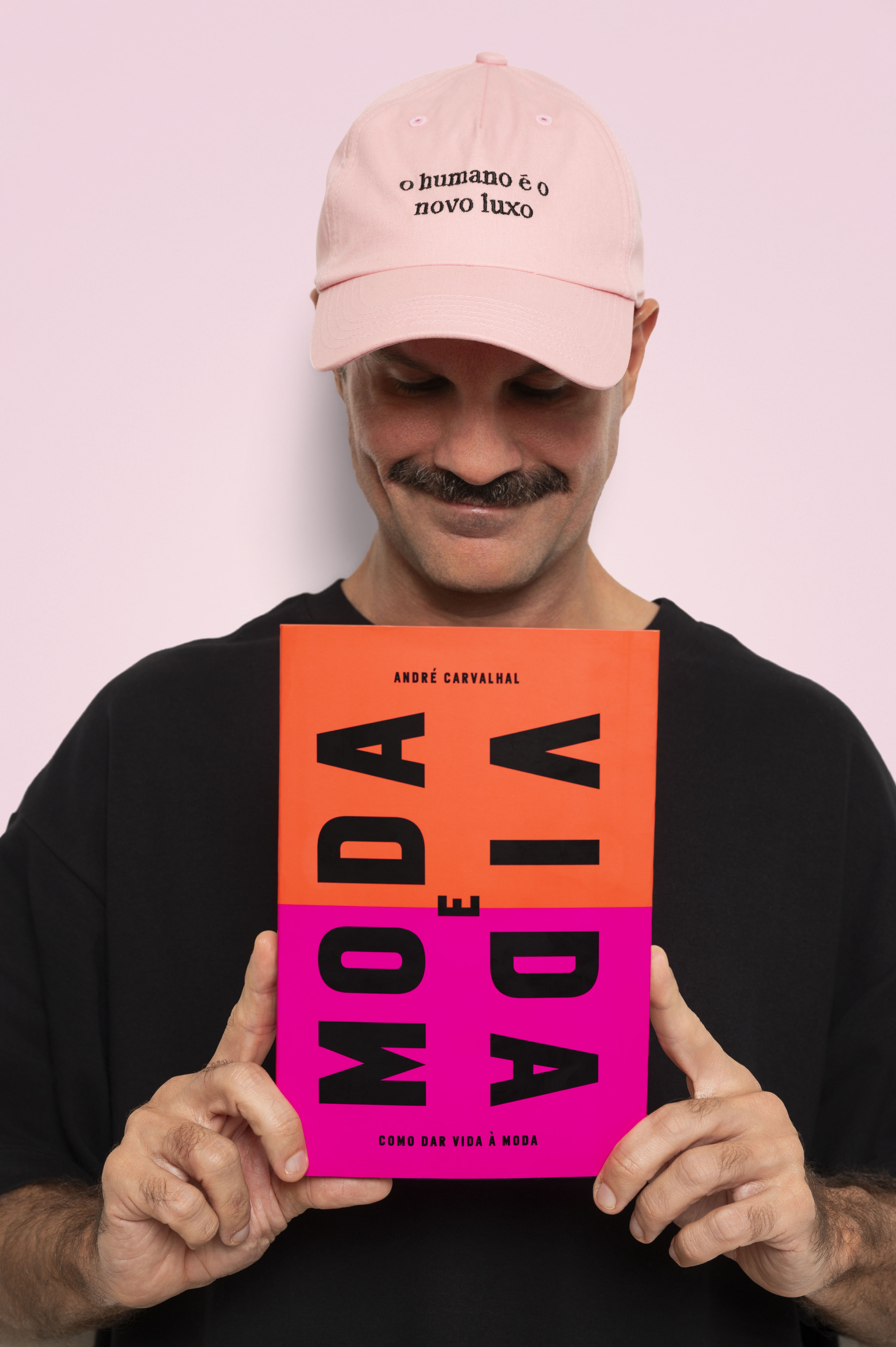 André Carvalhal segura o livro Moda e Vida: Como dar vida à moda